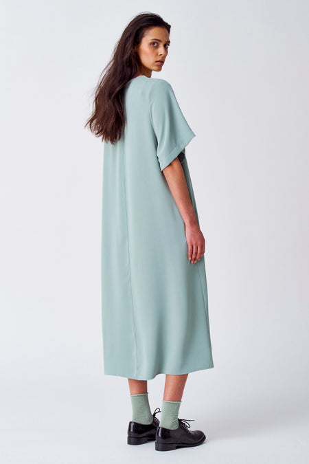 Robe verte avec manches courtes de YŪGEN, vue de derrière, avec des chaussettes coordonnées et des chaussures noires.