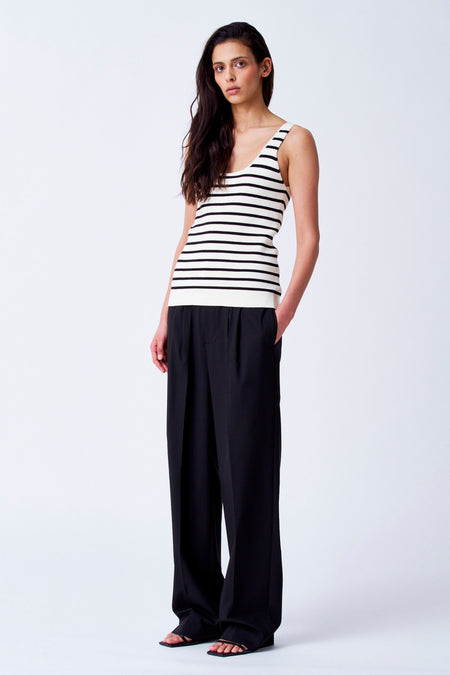 T-shirt beige de YŪGEN, avec des rayures noires et porté avec un pantalon noir.