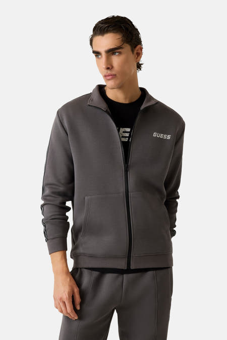 Gilet gris de Guess® avec une encolure haute et un motif logo noir le long des manches.
