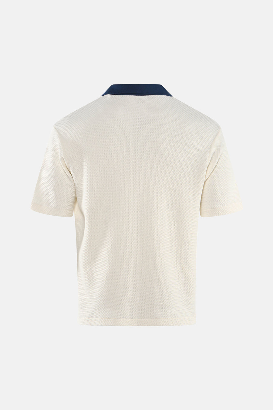 Polo écru à manches courtes de Guess, avec un col bleu foncé et une texture subtile.