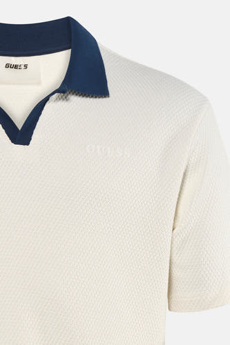 Polo écru à manches courtes de Guess, avec col bleu marine et texture subtile.