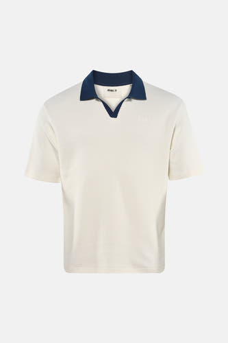 Polo écru à manches courtes de Guess, avec col bleu marine et logo discret sur la poitrine.