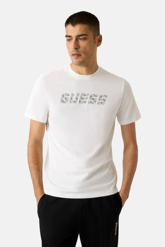 T-shirt blanc à manches courtes de Guess, vu de l'arrière, associé à un pantalon noir.