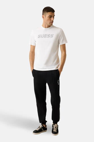 T-shirt blanc à manches courtes de Guess avec un logo imprimé sur la devant.