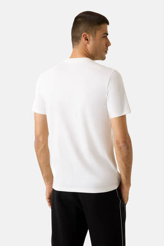 Wit T-shirt met korte mouwen van Guess, achterkant gezien, gecombineerd met een zwarte broek.