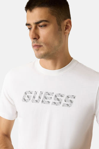 T-shirt blanc à manches courtes de Guess, avec une impression graphique du logo sur la partie avant.