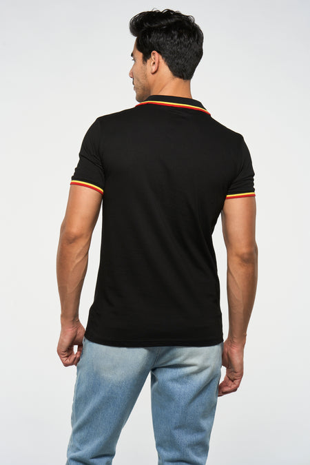 T-shirt noir de ZEB STYLE LAB, vu de derrière, avec des accents rouges et jaunes au niveau du col et des manches, porté avec un jean.