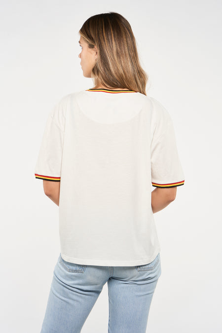T-shirt blanc de ZEB STYLE LAB, avec col rond et finition noire, rouge et jaune, vu de dos, porté avec des jeans.